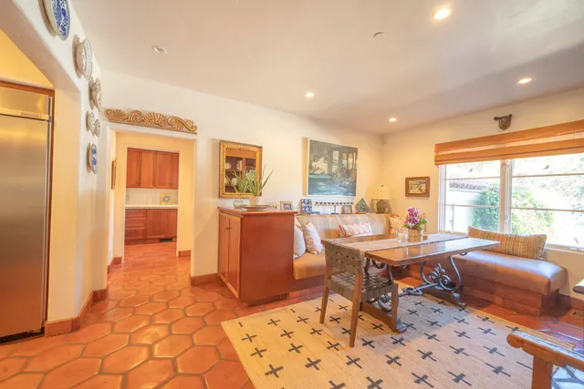 a work room with furniture a rug and a window