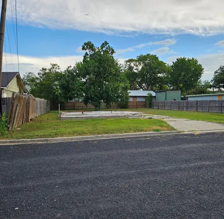 a view of a swimming pool with a yard and a large tree