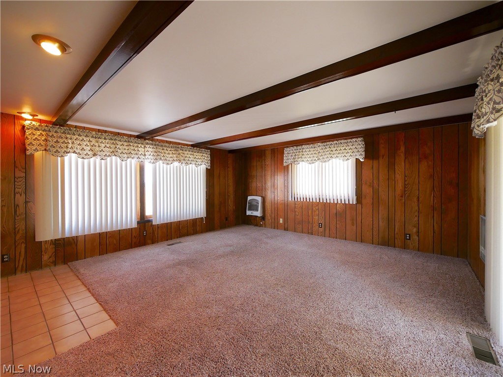 57500 Hospital Road Bellaire, OH 43906 - Photo 6 of 22 Tiled empty room featuring beam ceiling and wood walls