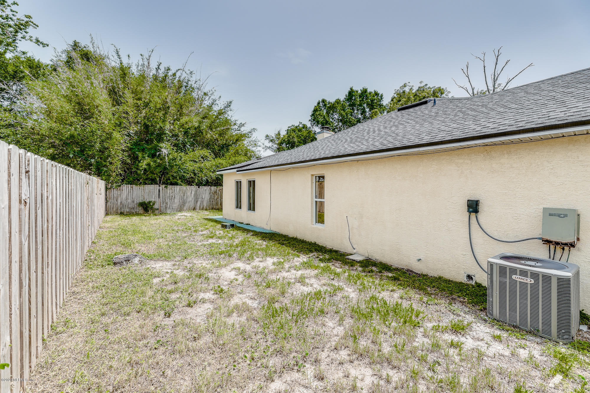 201 Warbler Road St. Augustine, FL 32086 - Photo 3 of 34 a backyard of a house with plants and wooden fence