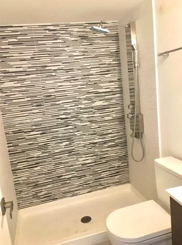 a bathroom with a toilet and a shower