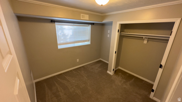3547 East Golden Eagle Road Eagle Mountain, UT 84005 - Photo 32 of 47 Unfurnished bedroom with dark carpet, ornamental molding, and a closet