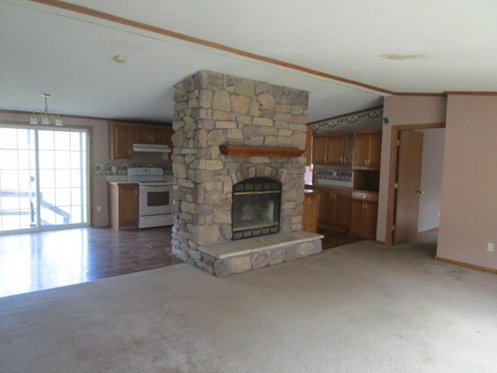 416 Plum Sock Road Prosperity, PA 15329 - Photo 3 of 22 an empty room with fireplace wooden floor and windows