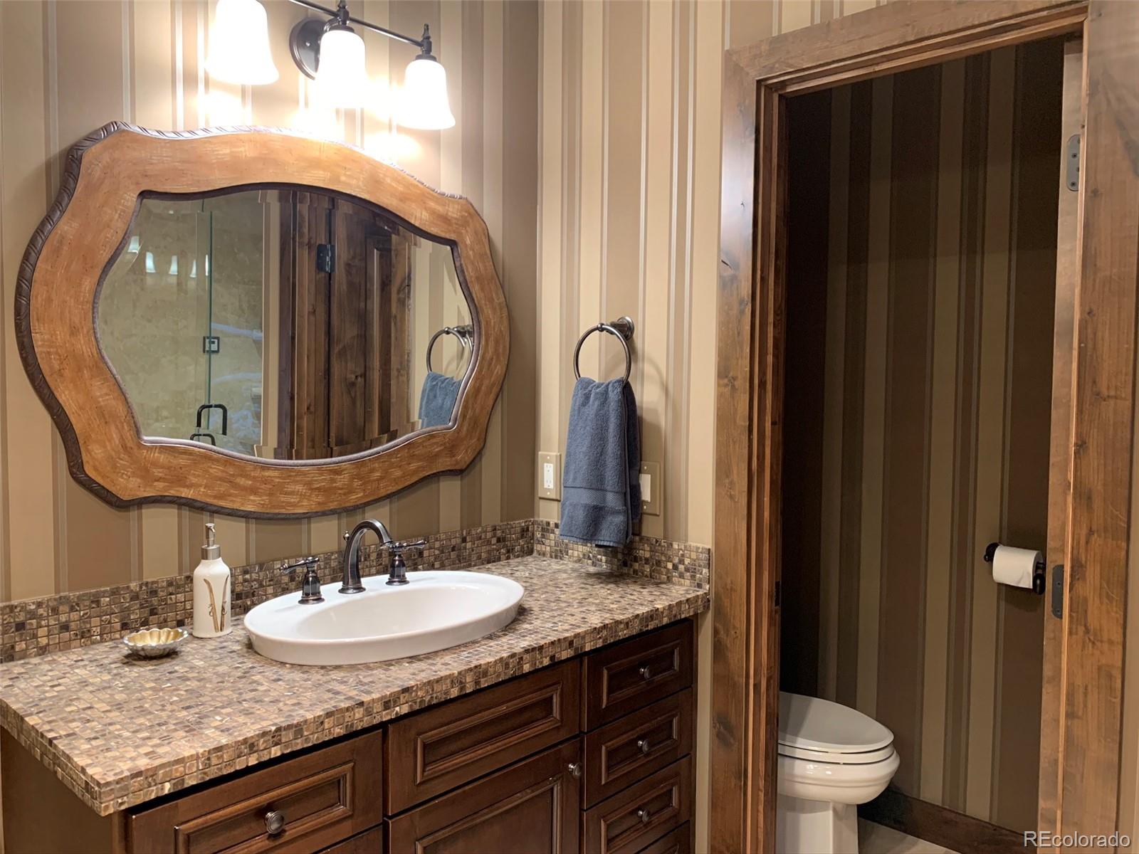 5148 Gore Circle Vail, CO 81657 - Photo 16 of 22 a bathroom with a granite countertop sink and a mirror