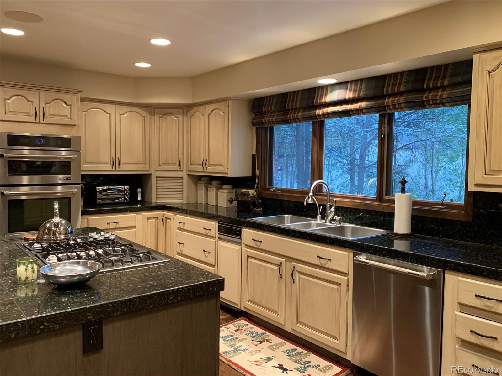 5148 Gore Circle Vail, CO 81657 - Photo 6 of 22 a kitchen with stainless steel appliances granite countertop a sink stove and refrigerator