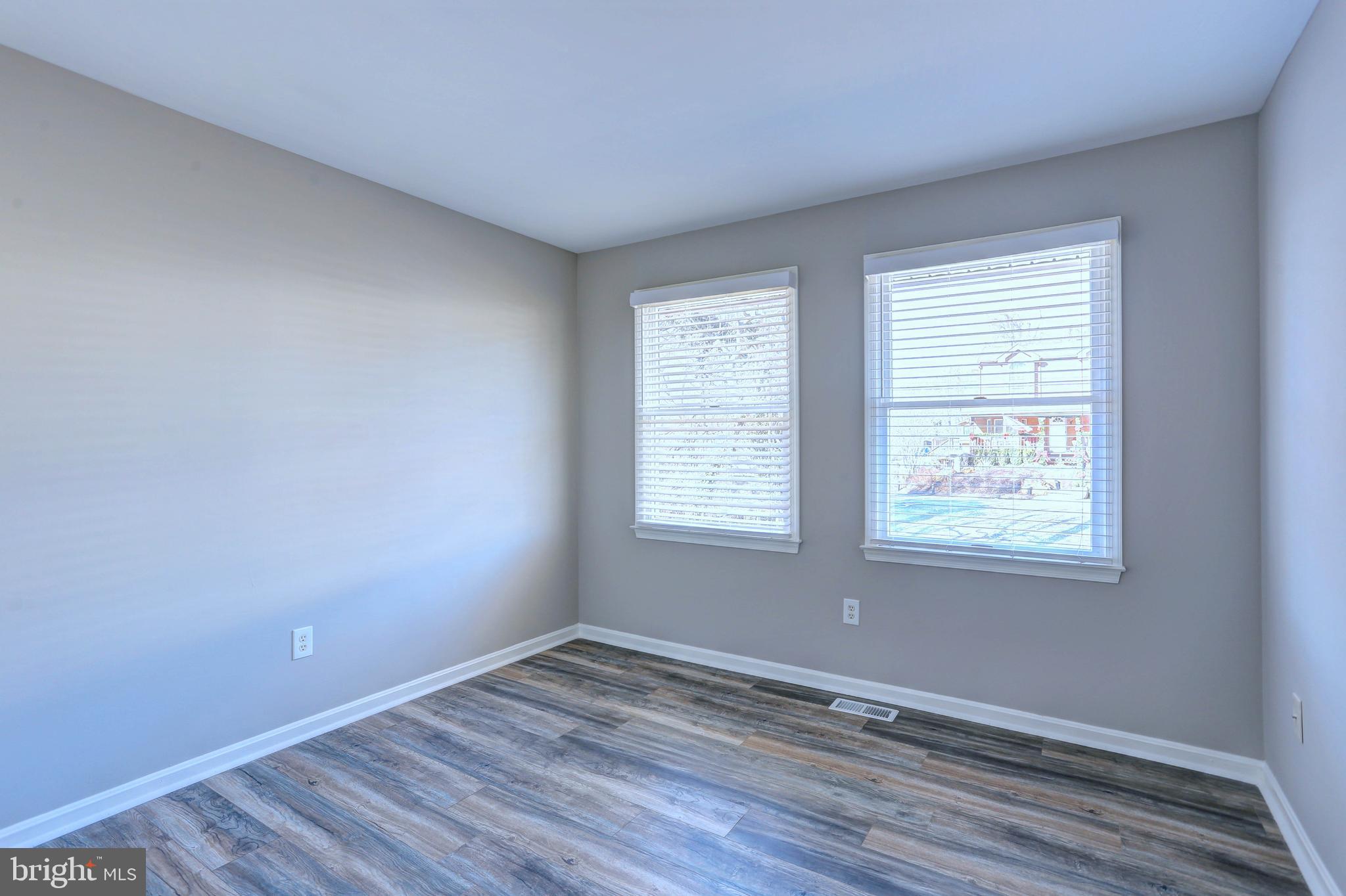 9575 Cissell Avenue Laurel, MD 20723 - Photo 13 of 34 an empty room with wooden floor and windows