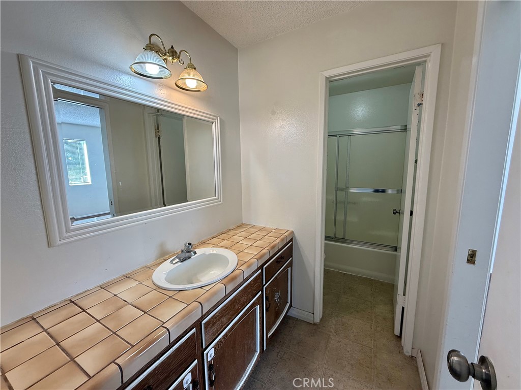 9920 Jurupa Road Jurupa Valley, CA 92509 - Photo 5 of 13 a bathroom with a sink a light fixture and a mirror