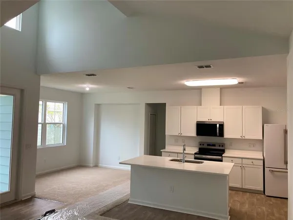 a kitchen with stainless steel appliances white cabinets and a refrigerator