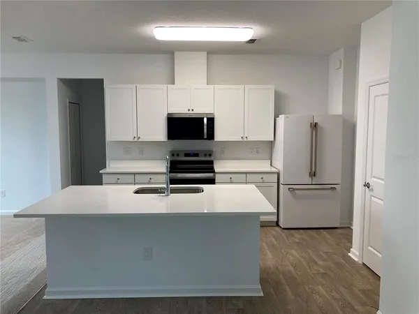 a kitchen with white cabinets and stainless steel appliances