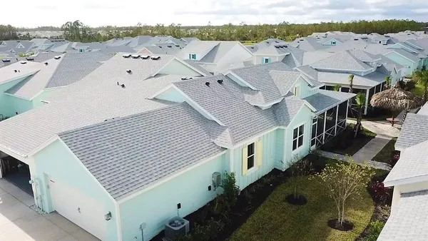 an aerial view of residential houses with outdoor space and parking