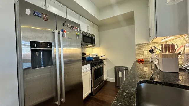 a kitchen with stainless steel appliances granite countertop a refrigerator and a stove