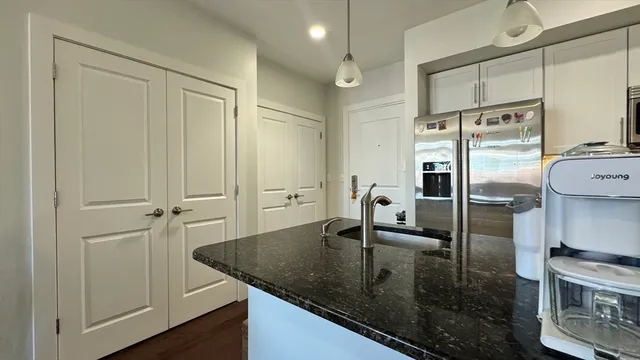 a kitchen with stainless steel appliances granite countertop a sink a stove and a refrigerator