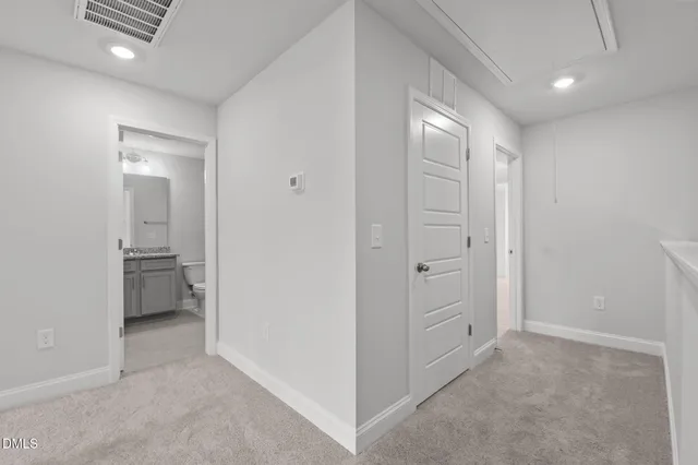a view of a hallway with closet and a bathroom