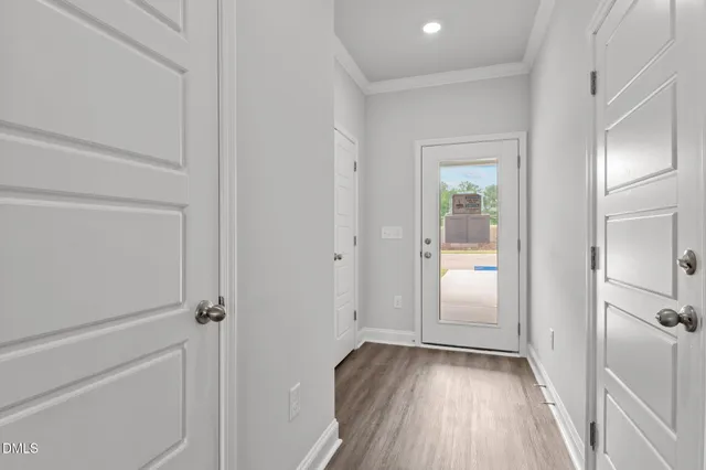 a view of a hallway with wooden floor and closet