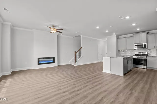 a view of kitchen with granite countertop a stove top oven and cabinets with wooden floor