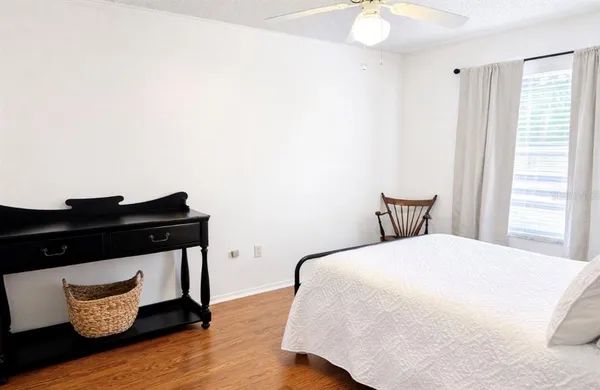 a bedroom with a bed and wooden floor