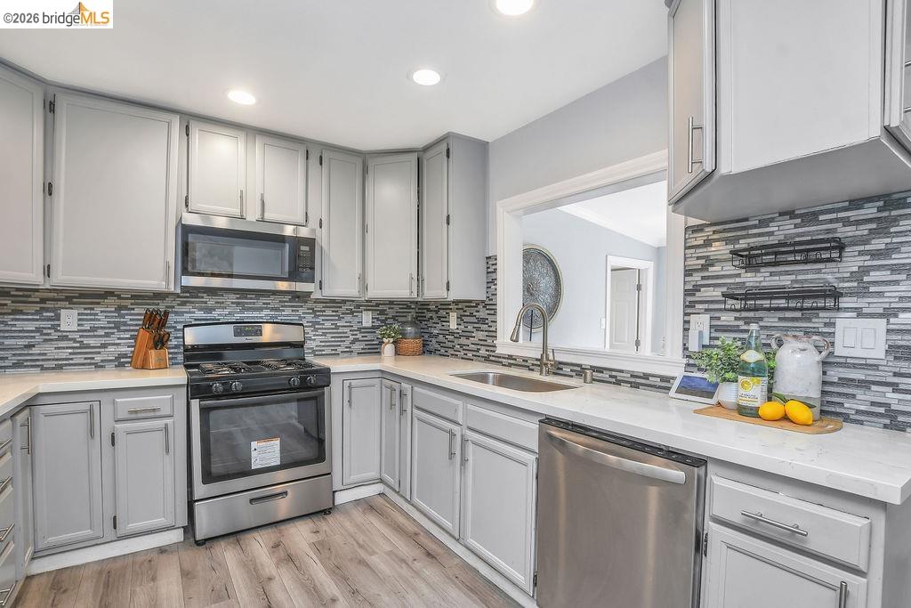 2191 East Cypress Road Oakley, CA 94561 - Photo 9 of 48 Kitchen featuring gray cabinets, stainless steel appliances, light stone counters, light wood-type flooring, and recessed lighting