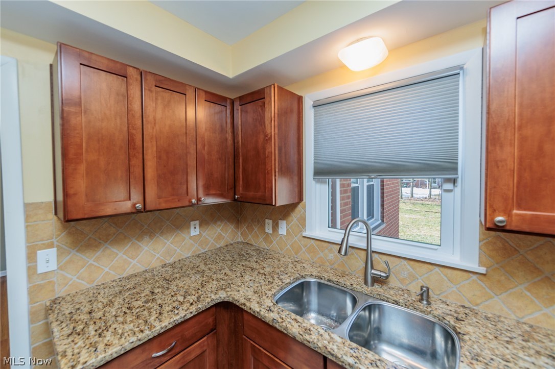 2444 Dysart Road Cleveland, OH 44118 - Photo 16 of 44 Kitchen with light stone countertops, backsplash, and sink