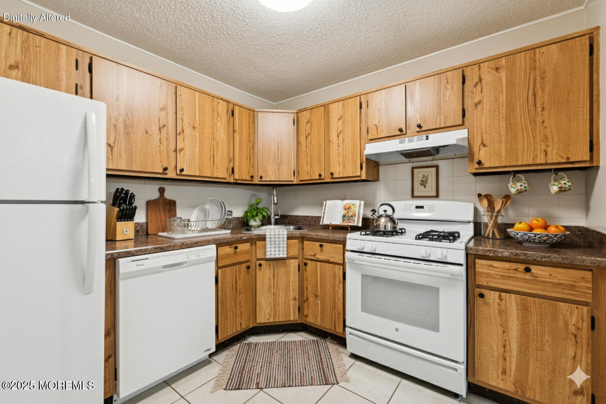 20-3 Austin Court, Unit 7 Freehold, NJ 07728 - Photo 12 of 31 a kitchen with stainless steel appliances granite countertop a refrigerator sink stove and white cabinets