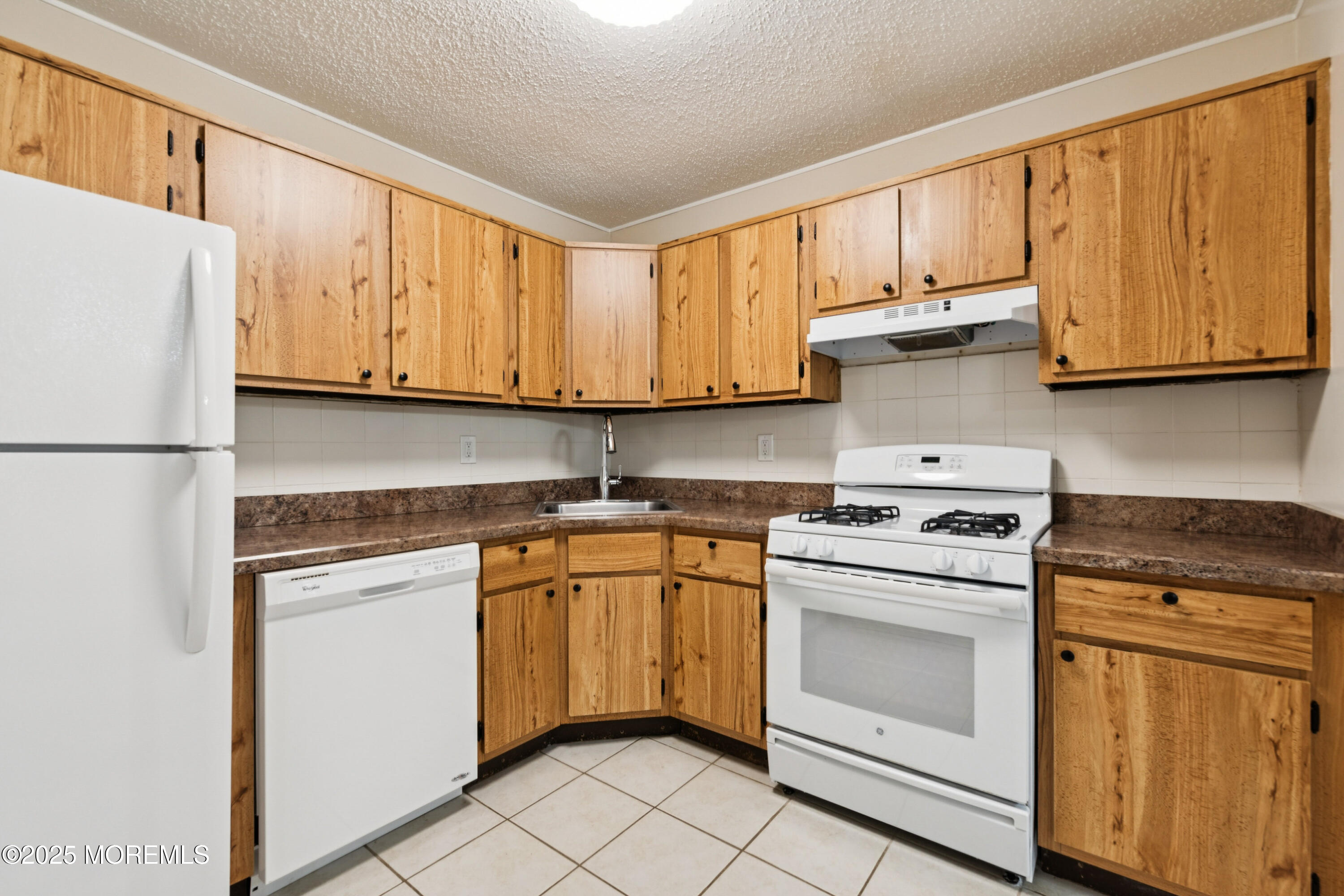 20-3 Austin Court, Unit 7 Freehold, NJ 07728 - Photo 13 of 31 a kitchen with stainless steel appliances granite countertop a sink and a refrigerator
