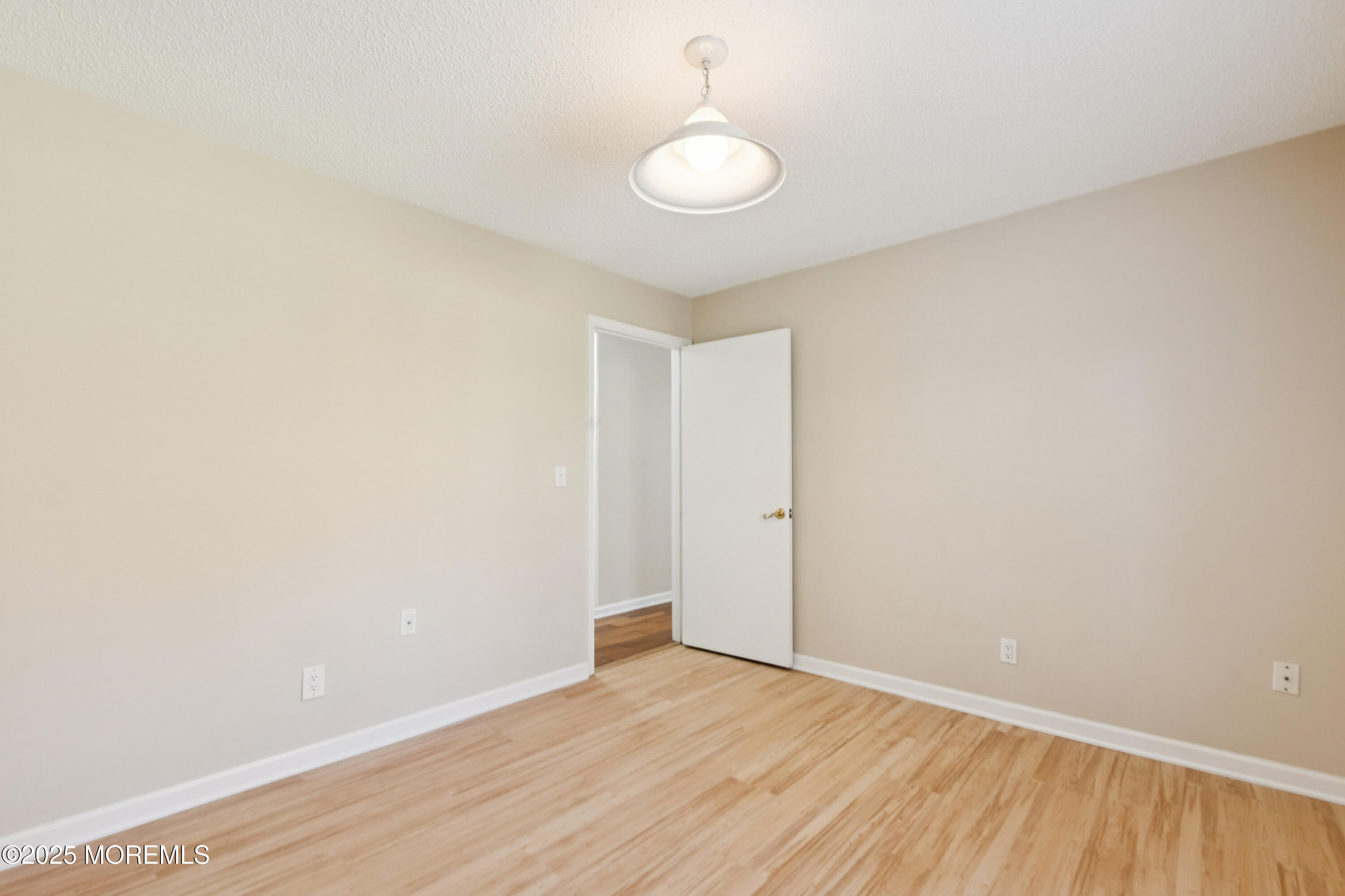 20-3 Austin Court, Unit 7 Freehold, NJ 07728 - Photo 18 of 31 a view of an empty room with wooden floor and a window