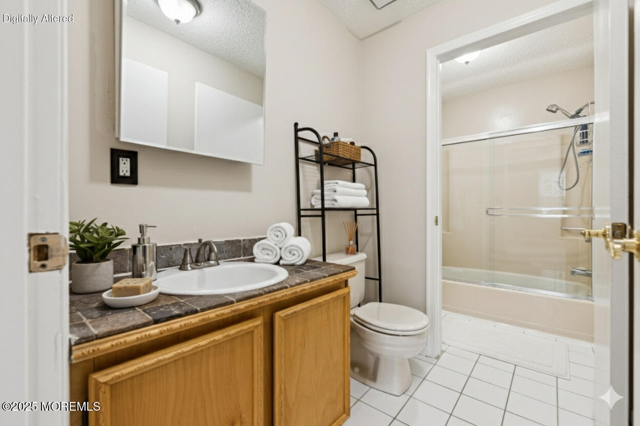 20-3 Austin Court, Unit 7 Freehold, NJ 07728 - Photo 25 of 31 a bathroom with a granite countertop sink a toilet and shower