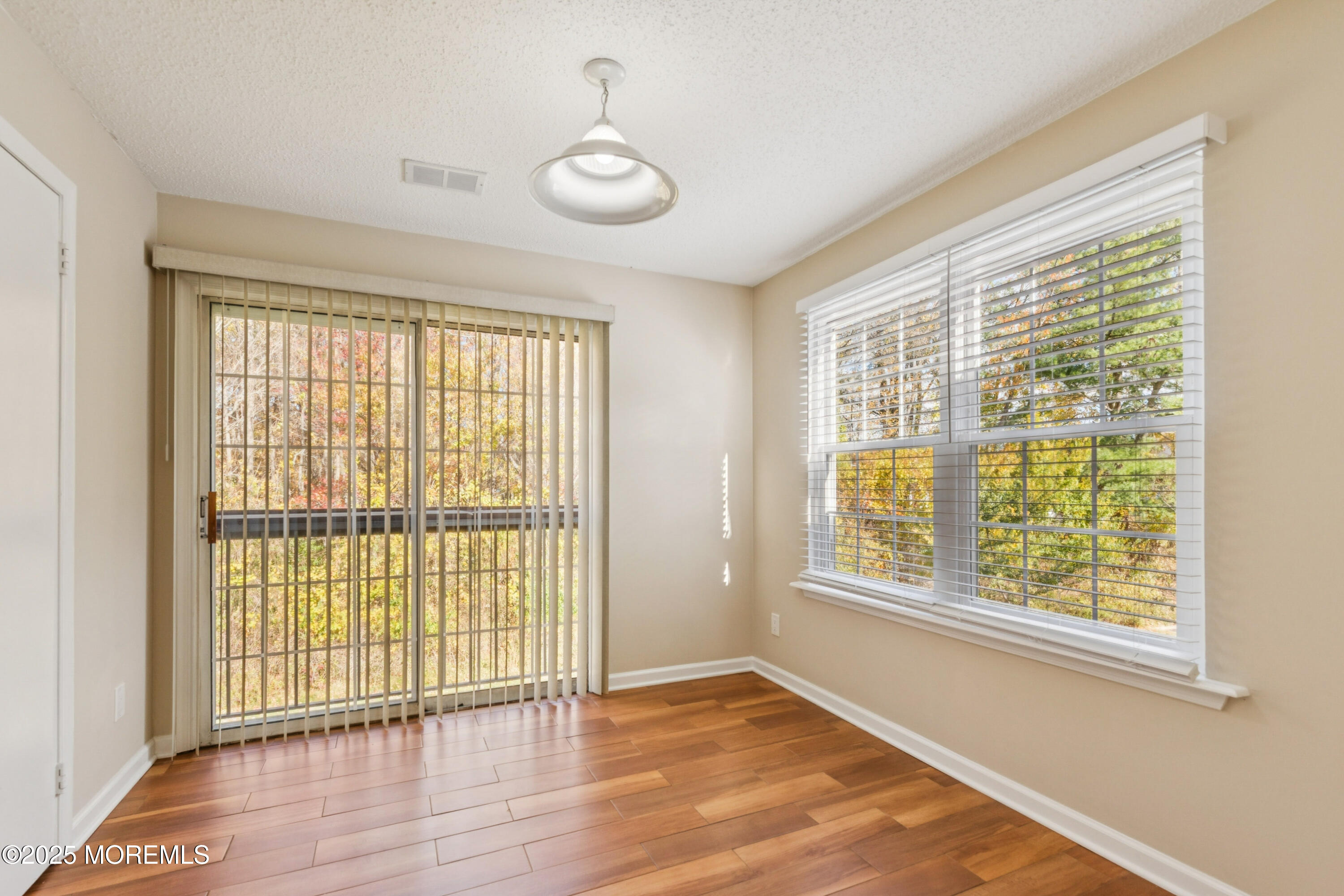 20-3 Austin Court, Unit 7 Freehold, NJ 07728 - Photo 4 of 31 a view of an empty room with wooden floor and a window