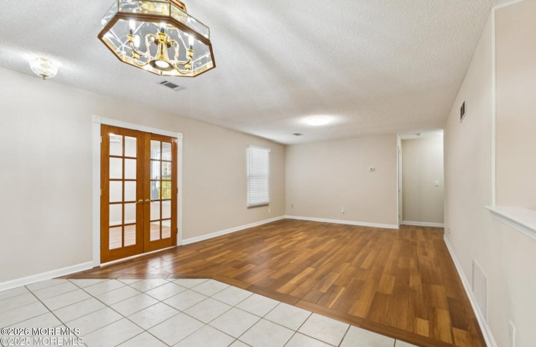 20-3 Austin Court, Unit 7 Freehold, NJ 07728 - Photo 8 of 31 an empty room with a chandelier