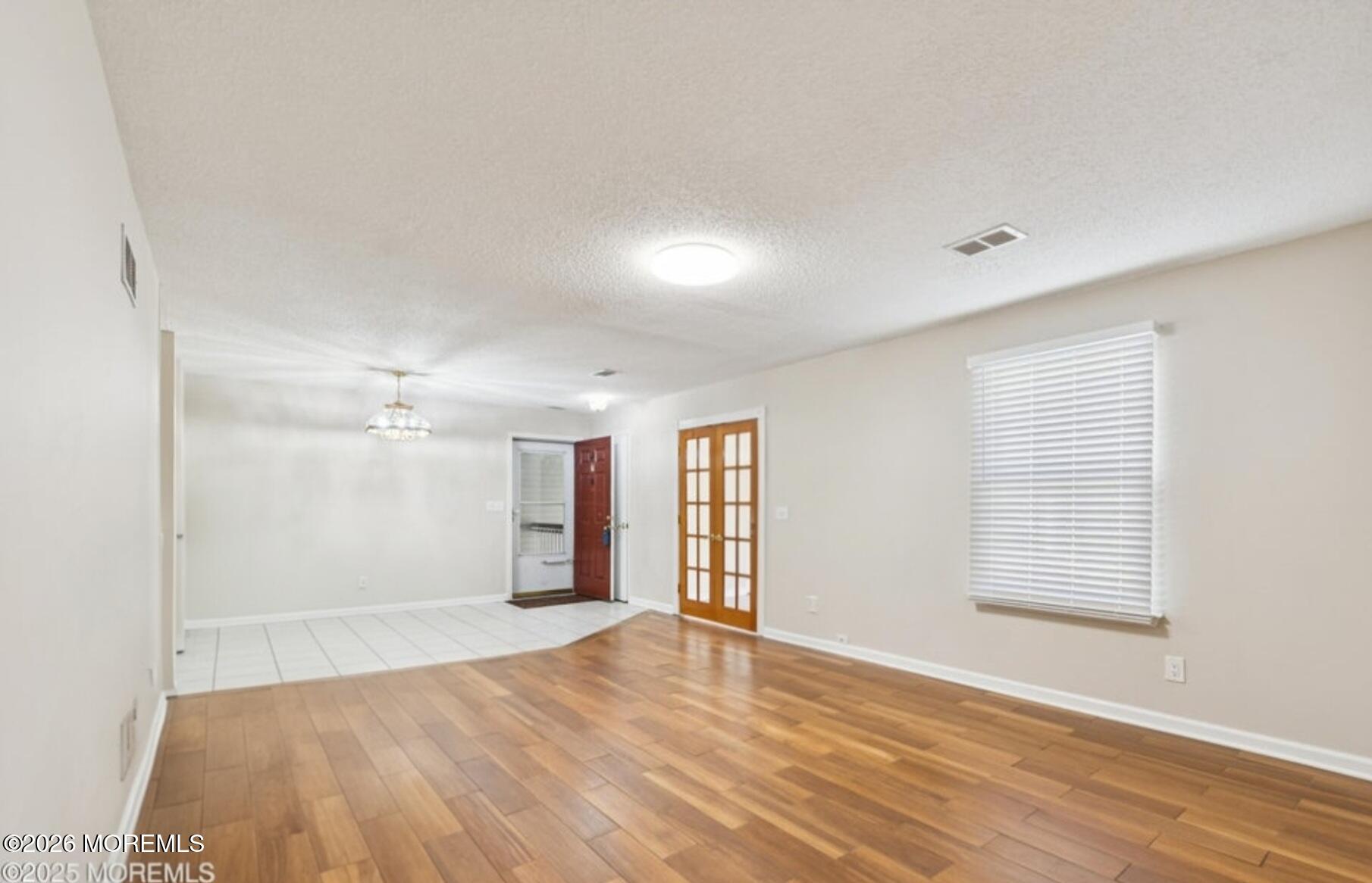 20-3 Austin Court, Unit 7 Freehold, NJ 07728 - Photo 10 of 31 an empty room with wooden floor and windows