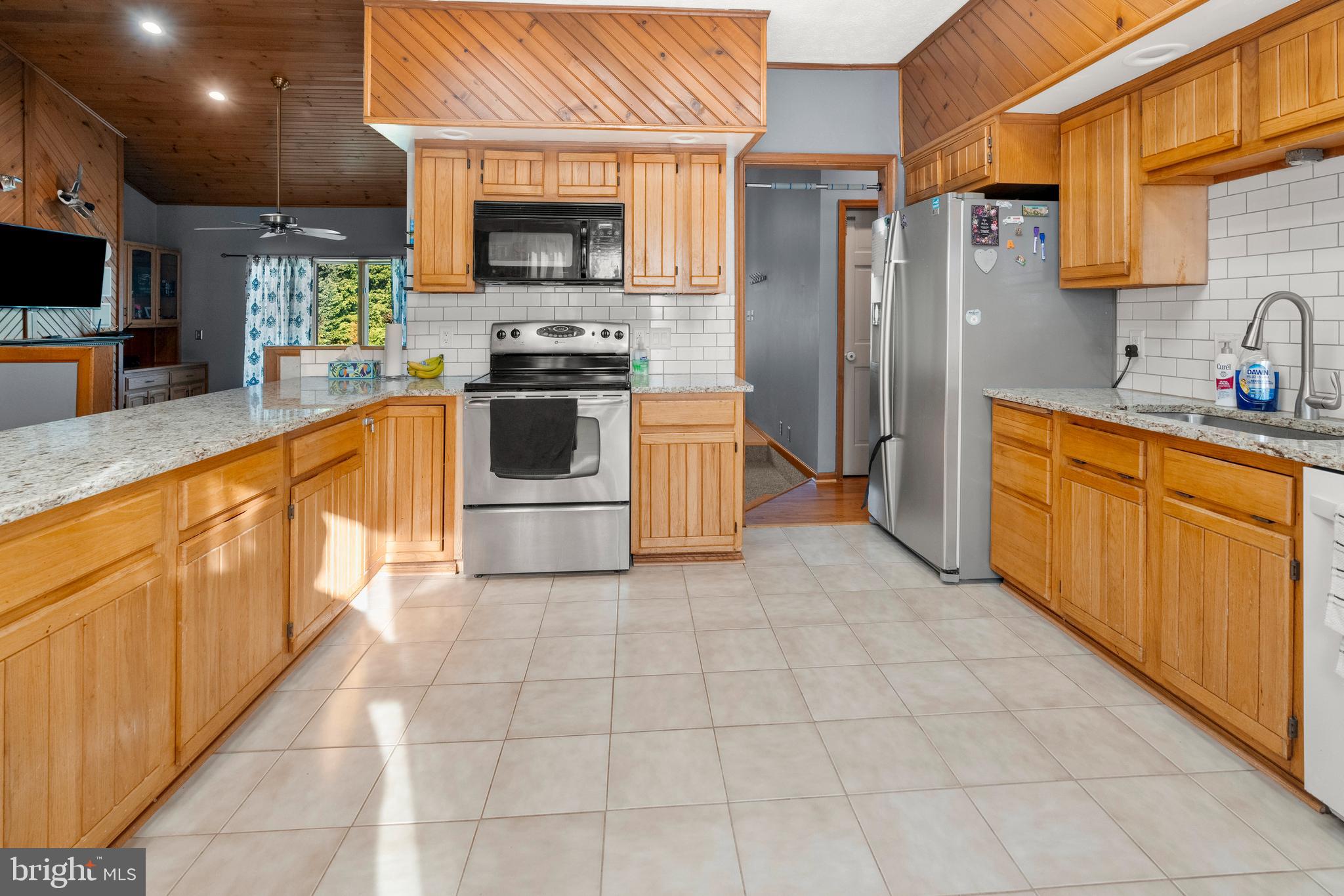 133 Roop Road Rising Sun, MD 21911 - Photo 15 of 58 a large kitchen with stainless steel appliances granite countertop a stove a sink and a microwave