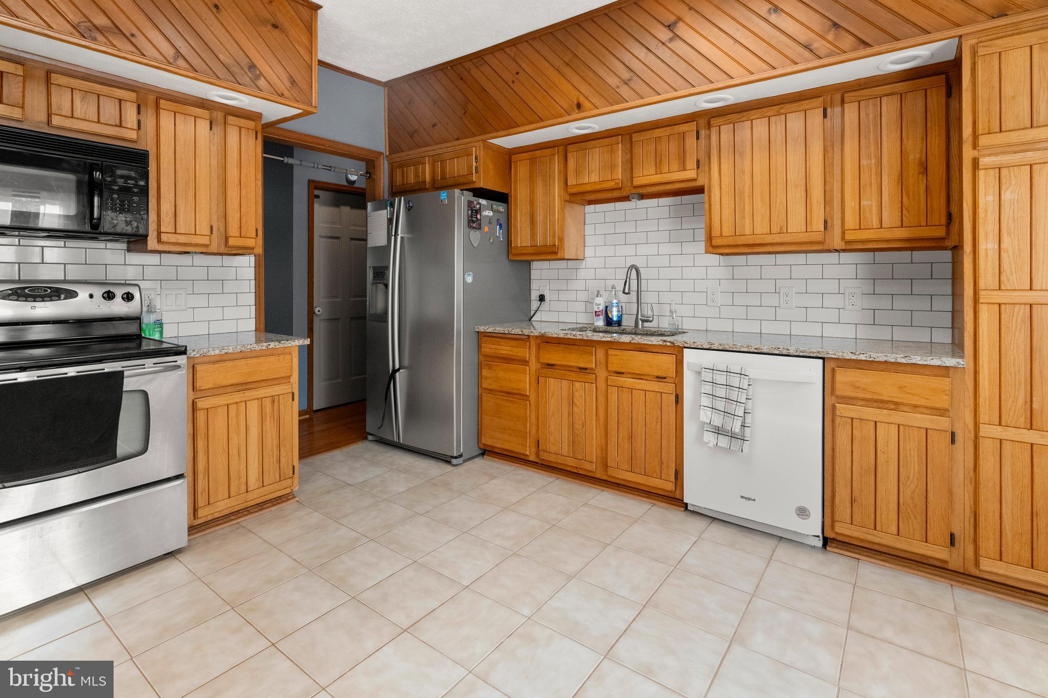 133 Roop Road Rising Sun, MD 21911 - Photo 16 of 58 a kitchen with stainless steel appliances granite countertop a stove a sink and a refrigerator