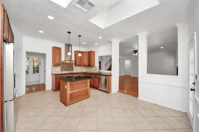 a kitchen with stainless steel appliances granite countertop a refrigerator a oven and a sink