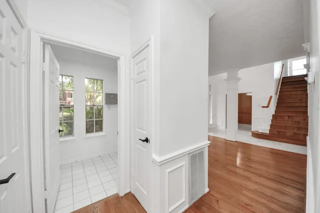 a view of an empty room with a window and wooden floor