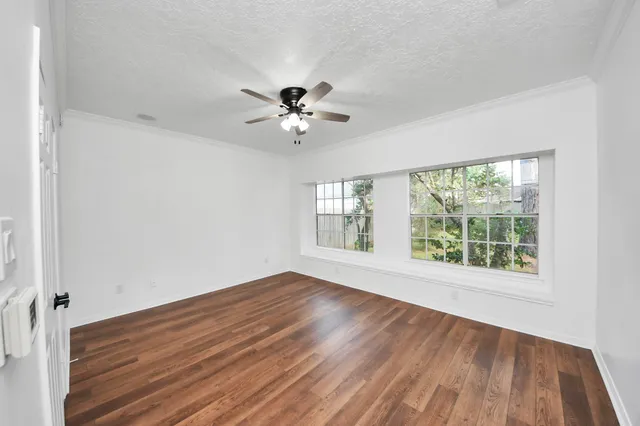 a view of empty room with wooden floor