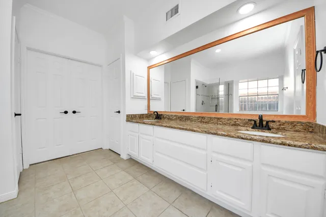a bathroom with a granite countertop tub sink and mirror