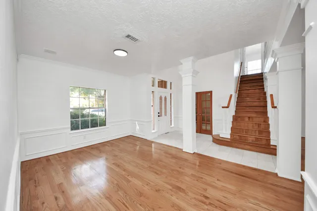 wooden floor in an empty room with a window