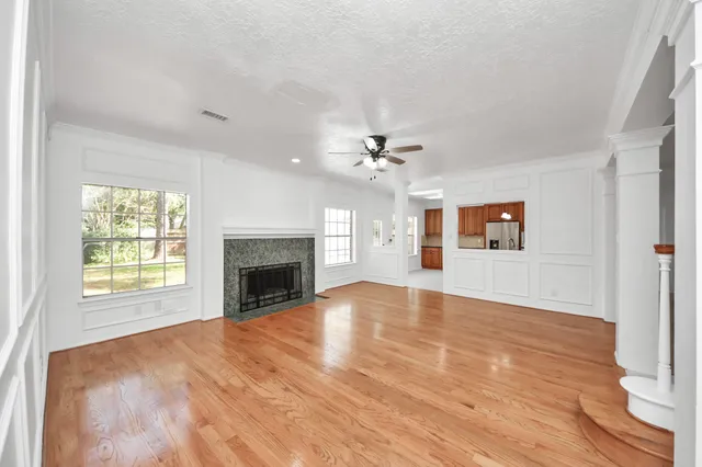 an empty room with windows and fireplace