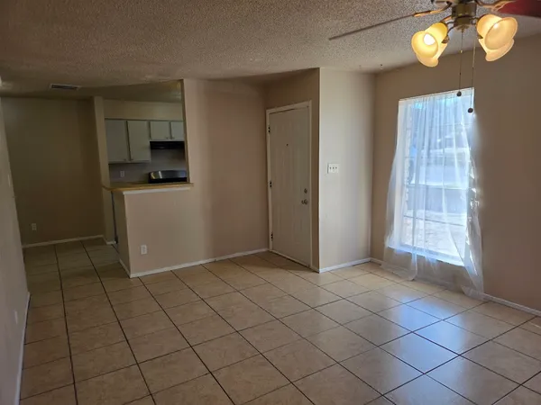 a view of an empty room with a fireplace and a window