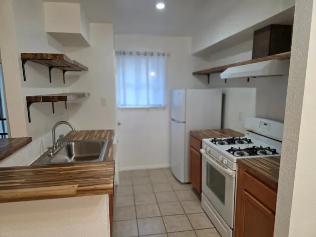 a kitchen with granite countertop a sink and a stove top oven