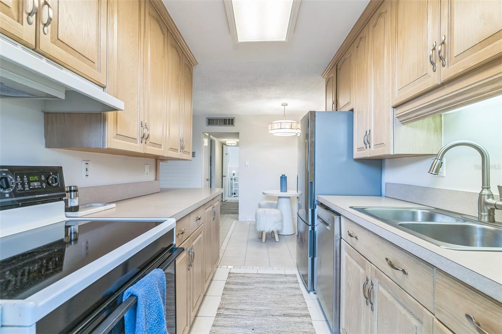 320 Lakeview Street, Unit 110 Orlando, FL 32804 - Photo 12 of 18 a kitchen with stainless steel appliances granite countertop a sink stove and cabinets