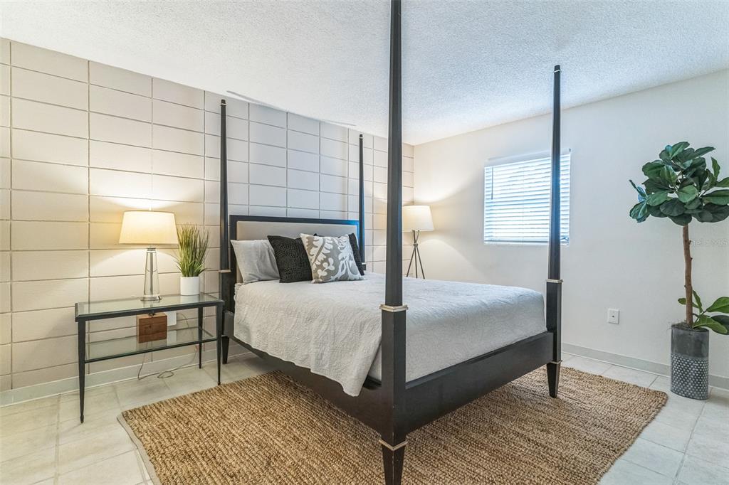320 Lakeview Street, Unit 110 Orlando, FL 32804 - Photo 13 of 18 a bedroom with a bed and a potted plant