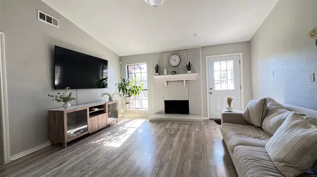 a living room with furniture a flat screen tv and a fireplace