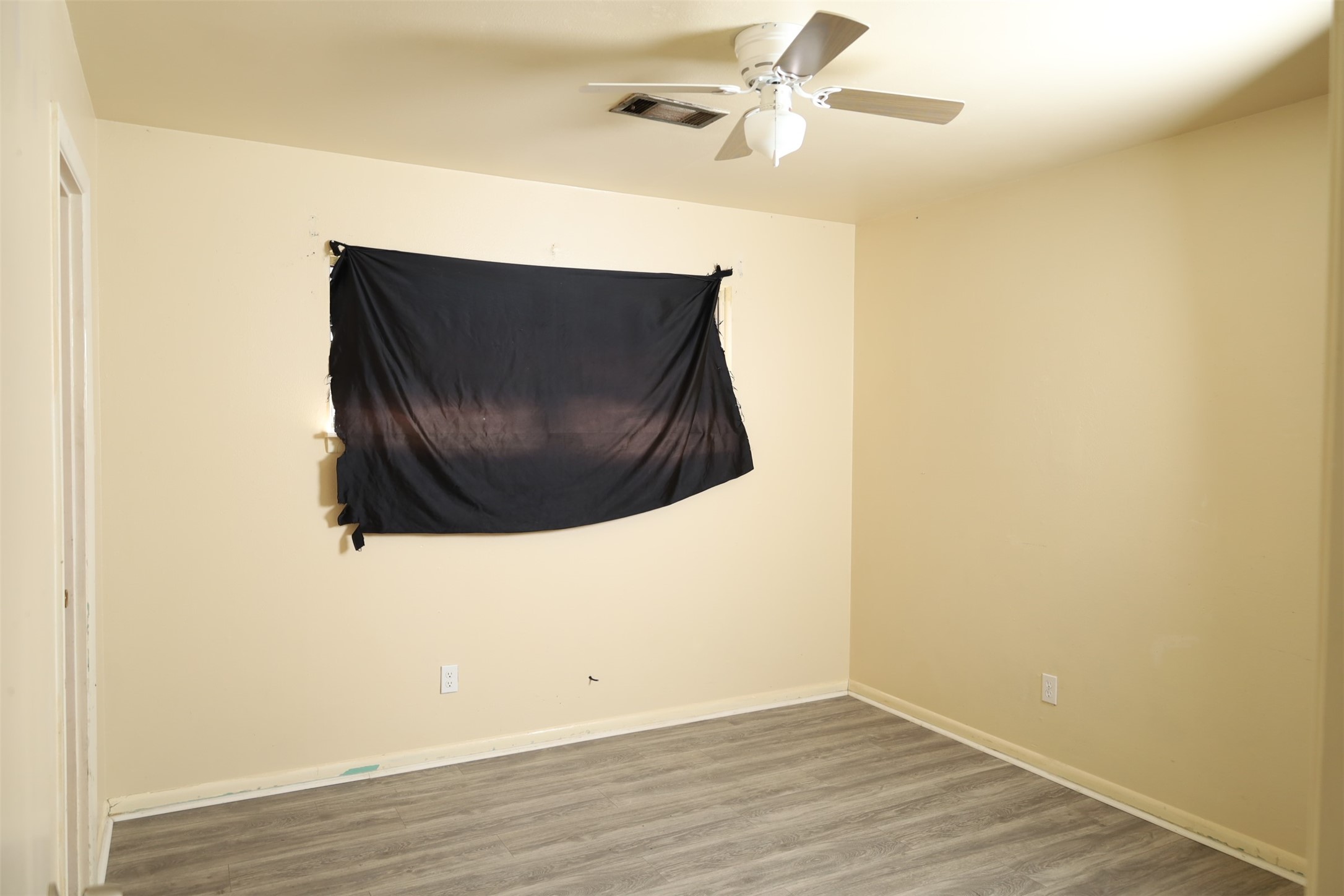 13207 Santa Teresa Road Houston, TX 77045 - Photo 12 of 20 an empty room with wooden floor and fan