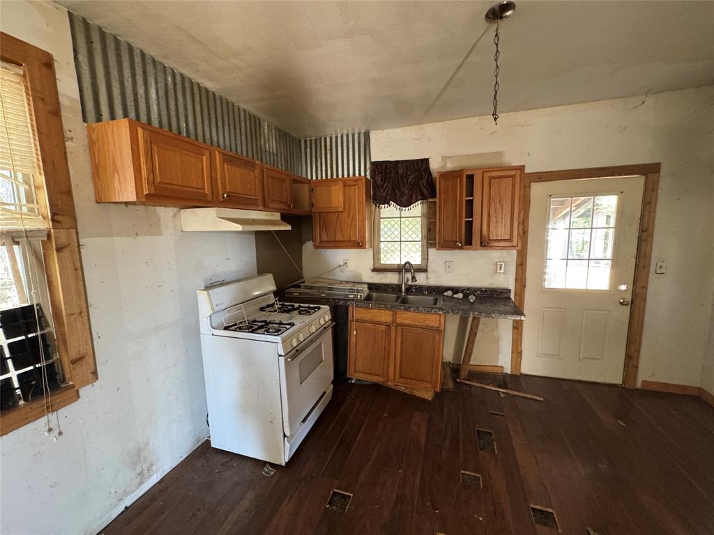 114 Main Street Haslet, TX 76052 - Photo 10 of 14 a kitchen with stainless steel appliances granite countertop a stove a sink dishwasher and a refrigerator with wooden floor