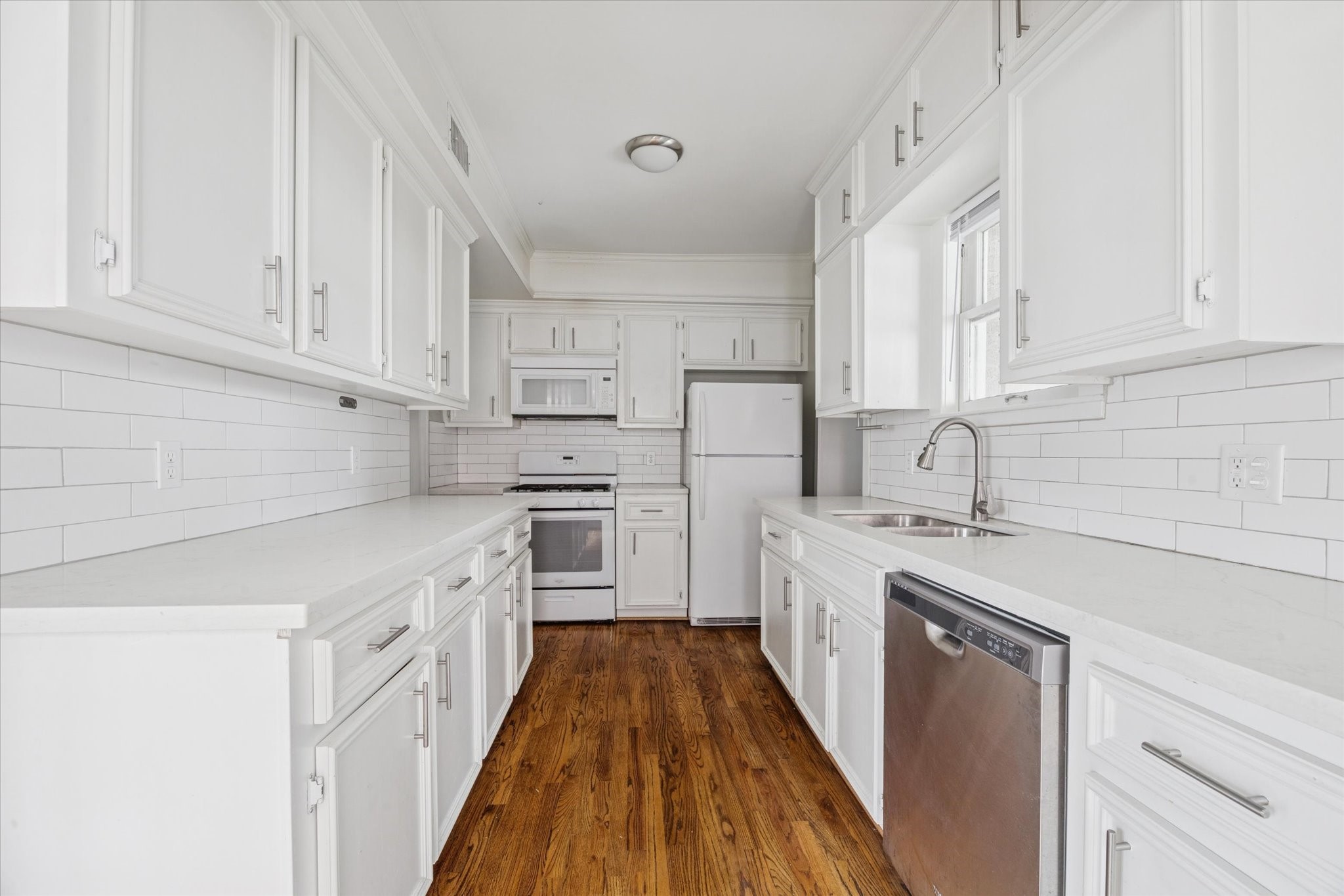 2510 Kingston Street, Unit 1 Houston, TX 77019 - Photo 6 of 12 a kitchen with white cabinets and white appliances