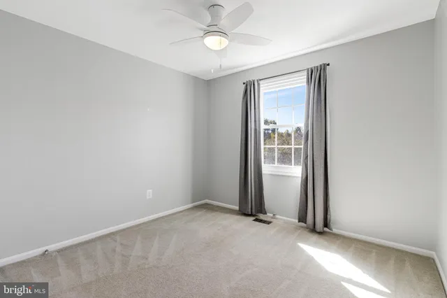 an empty room with closet and windows