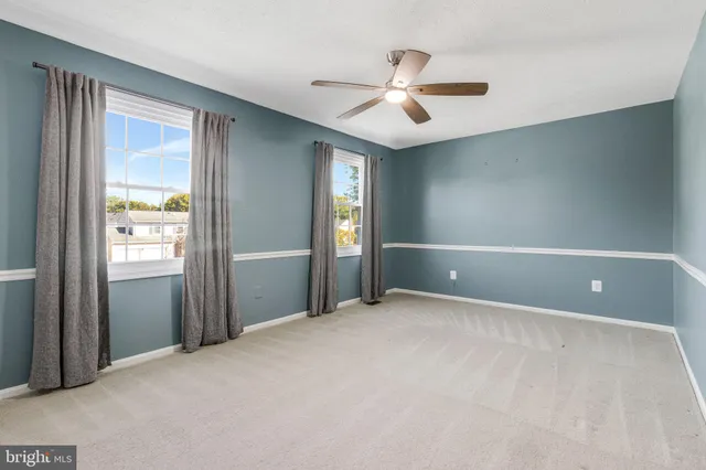 a view of an empty room with window and closet area
