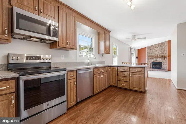 a kitchen with stainless steel appliances wooden floors and wooden cabinets