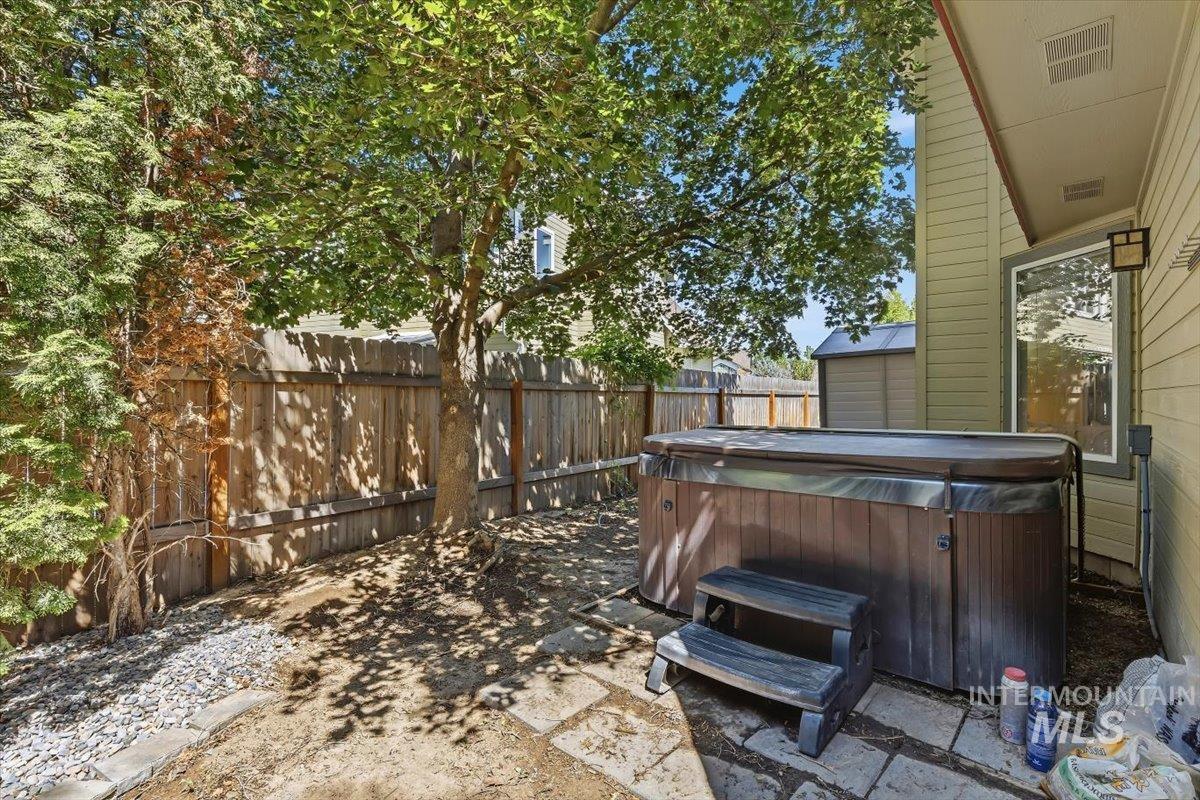 8001 West Innsbrook Court Boise, ID 83704 - Photo 36 of 39 Private backyard space featuring a hot tub with steps, stone pavers, and mature trees