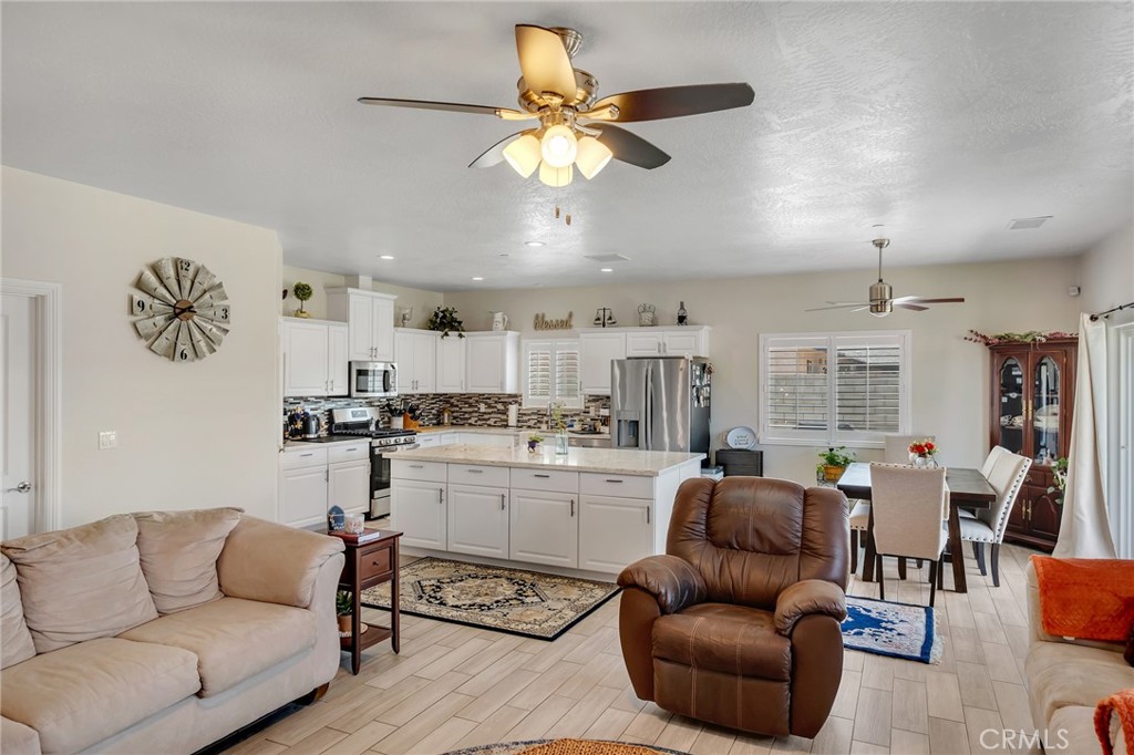 13178 Setancket Road Apple Valley, CA 92308 - Photo 7 of 24 a living room with furniture kitchen view and a chandelier